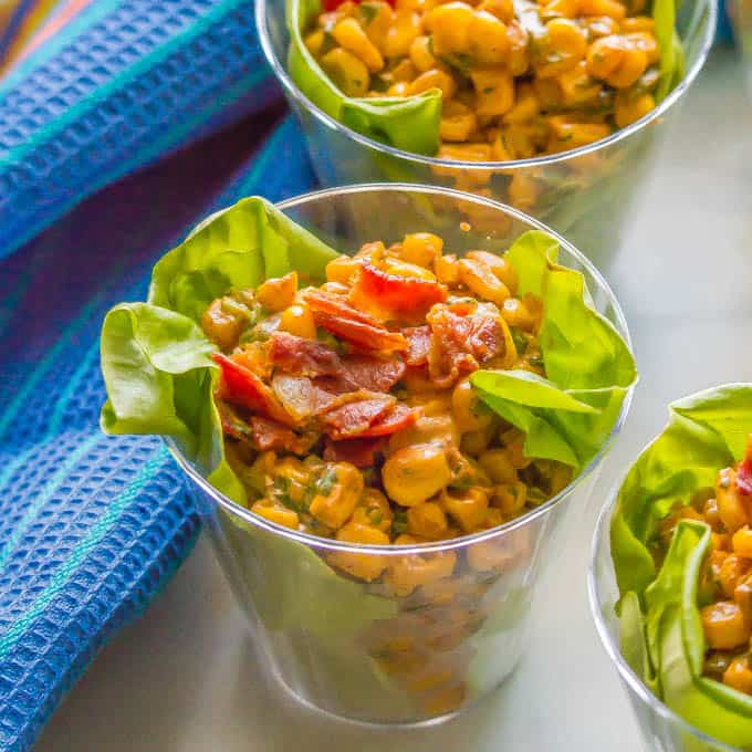 Summer corn salad with bacon on top served in an individual clear cup