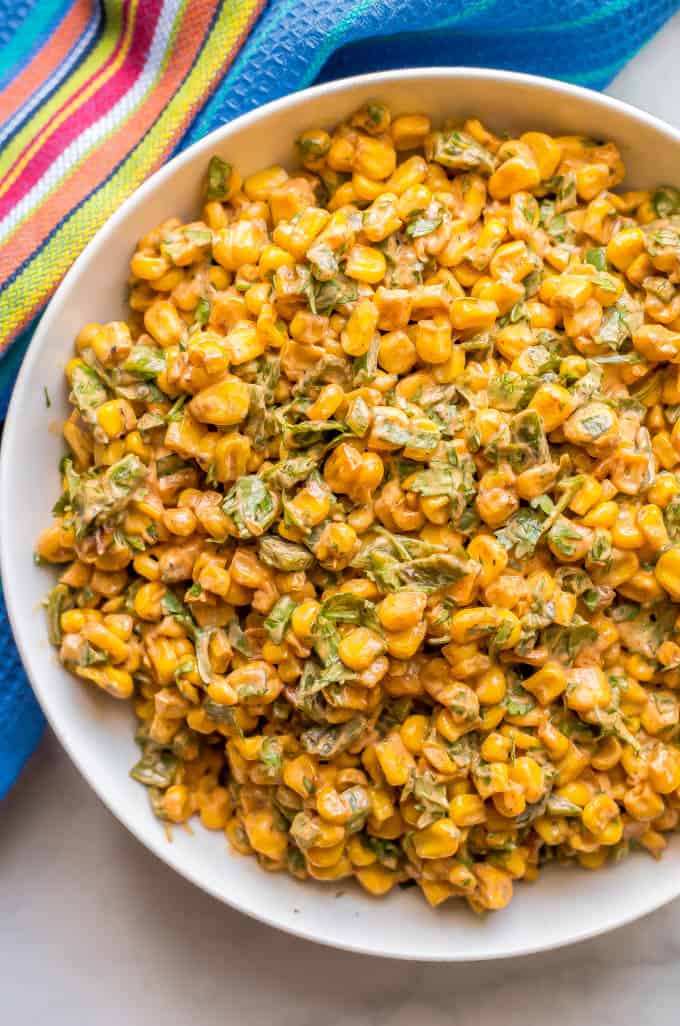 Creamy summer corn salad with poblano peppers in a white serving bowl