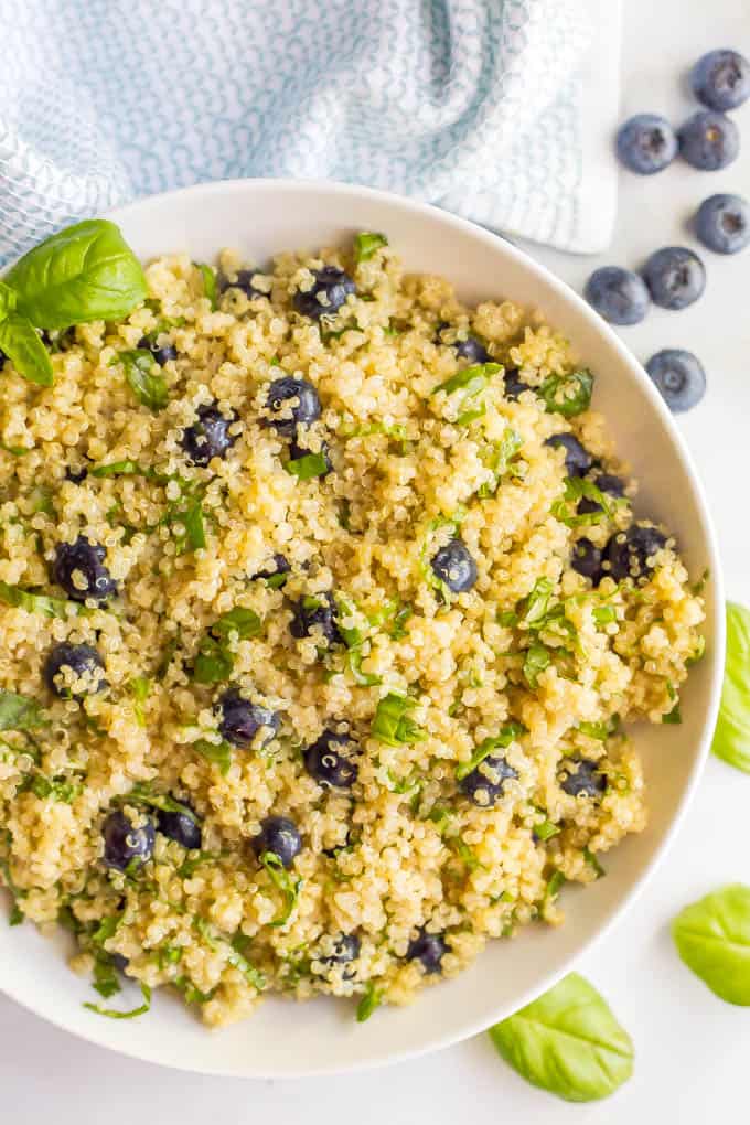 A quinoa salad with blueberries and basil in a low white bowl.