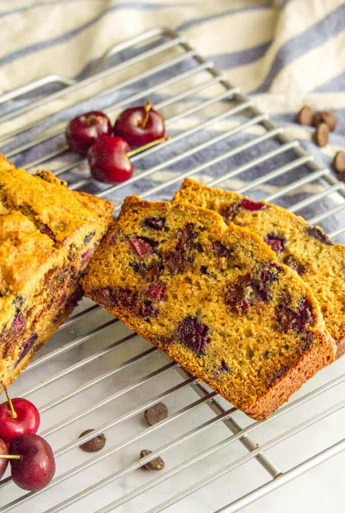 Slices of whole wheat cherry chocolate chip bread on a cooling rack