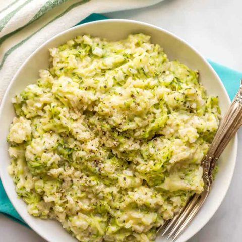 Easy cheesy zucchini brown rice being served in a large white bowl