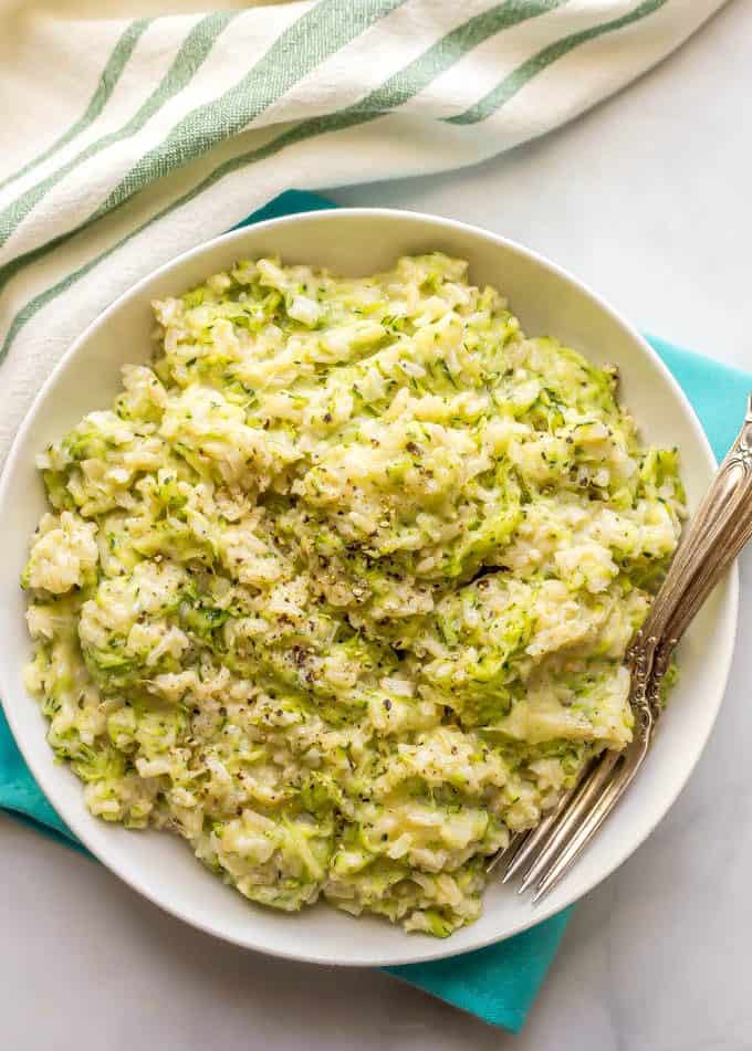 Easy cheesy zucchini brown rice being served in a large white bowl