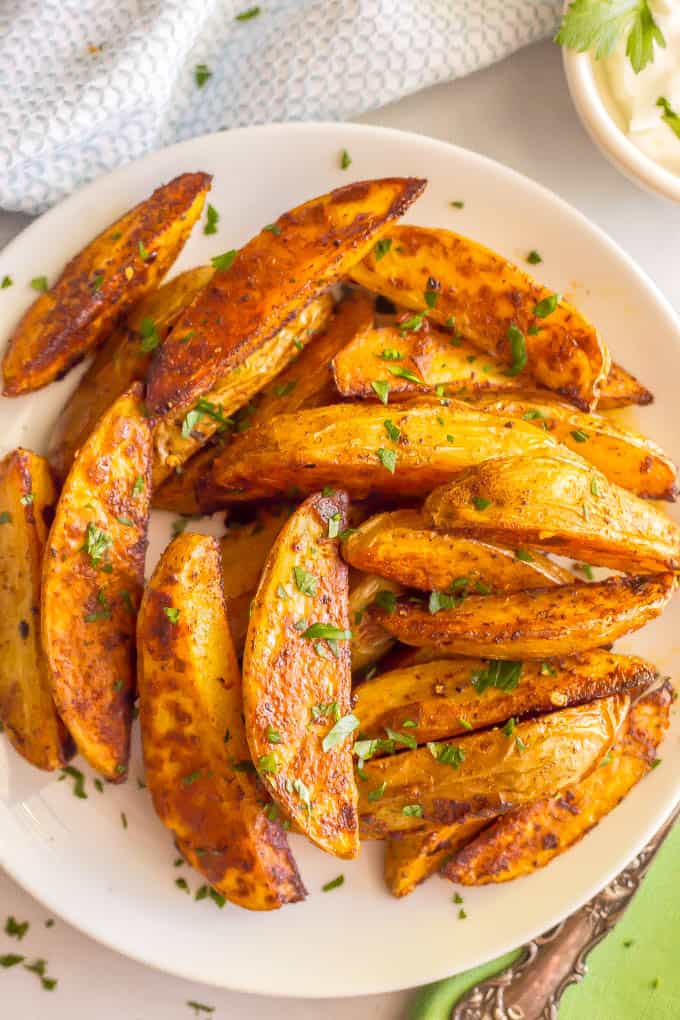 Easy spicy roasted potatoes require just a few pantry ingredients to create a truly delicious side dish with a bit of a kick! These potato wedges are crispy and crunchy on the outside with a tender, fluffy center. #roastedpotatoes #potatoes #spicyfood