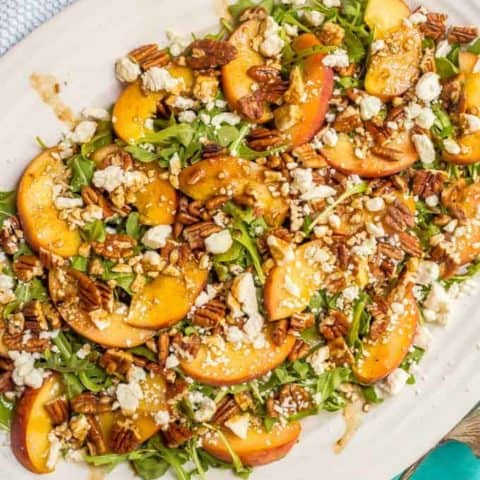 Arugula salad with peaches, pecans and goat cheese with balsamic vinaigrette is perfect for an easy, light and delicious summer side salad! #arugulasalad #peachrecipes #summersalad #saladrecipes #lowcarbrecipes #glutenfreerecipes