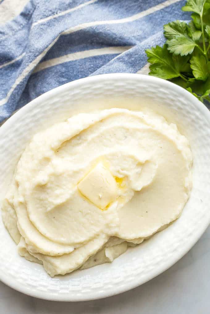 Healthy mashed cauliflower is creamy, smooth and an easy, delicious low-carb option for a dinner side dish. Just 4 ingredients and ready in just 20 minutes, you’ll love this mashed cauliflower on its own or with your favorite potato toppings! #cauliflower #lowcarb #glutenfree #sidedish