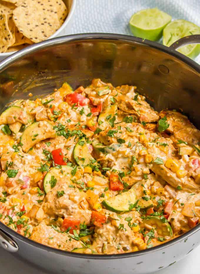 Queso chicken skillet with vegetables in a large skillet with cilantro sprinkled on top