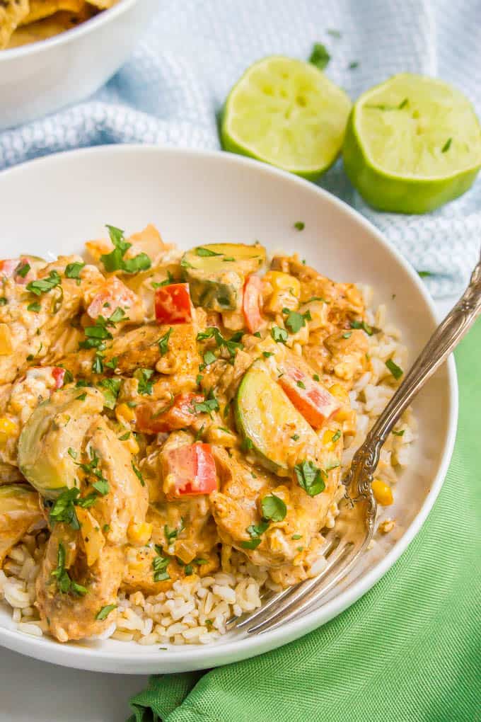 Queso chicken skillet with vegetables served over rice in a white bowl