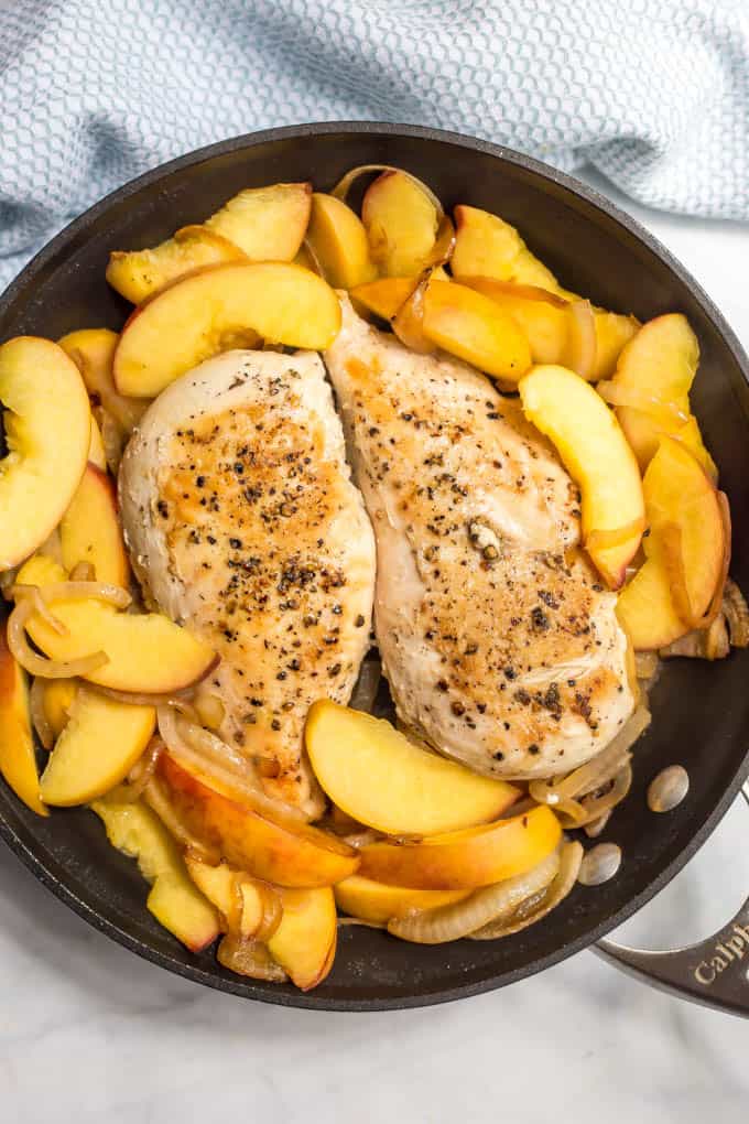 Seared skillet chicken breasts with peaches in a pan