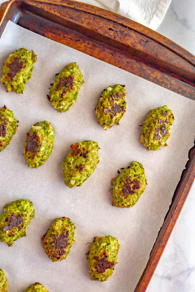 Baked broccoli tots on a baking sheet with parchment paper