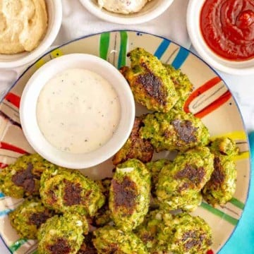 Homemade broccoli tots served with a variety of different dipping sauces in small bowls.