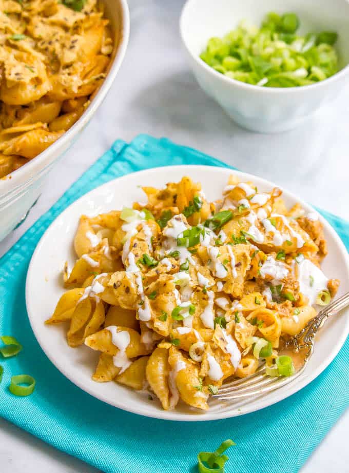 Baked taco mac and cheese casserole dinner served on a white plate with a fork alongside