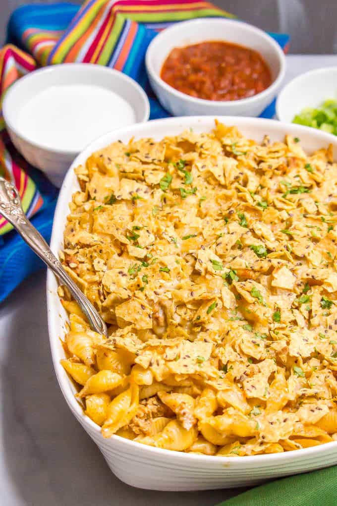 Baked taco mac and cheese casserole is an easy, family-friendly dinner with a creamy sauce and big taco flavor. Add your favorite toppings and dig in! #macandcheese #macaroni #pastadinner #tacos #tacodinner