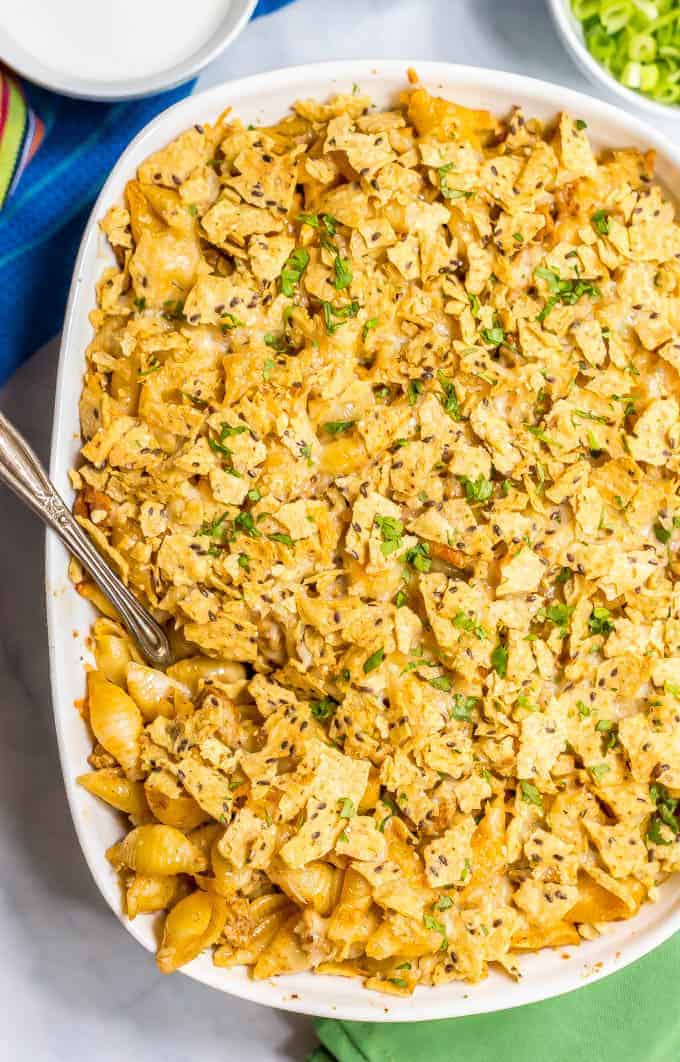 Baked taco mac and cheese casserole is an easy, family-friendly dinner with a creamy sauce and big taco flavor. Add your favorite toppings and dig in! #macandcheese #macaroni #pastadinner #tacos #tacodinner