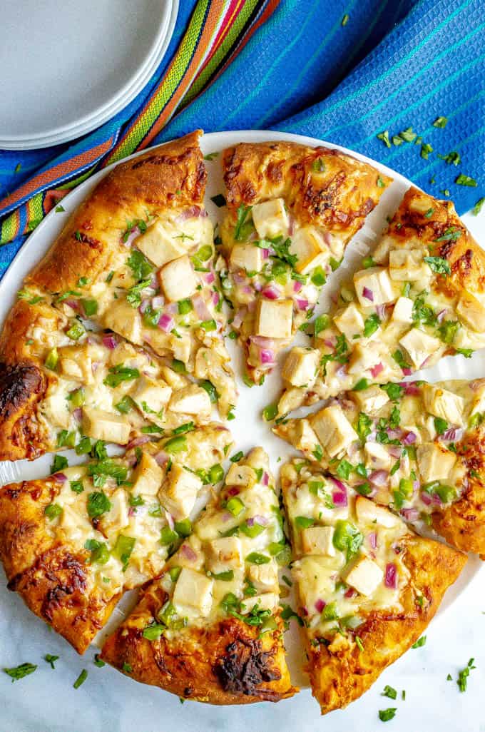 Easy BBQ chicken pizza served with fresh cilantro on a white plate