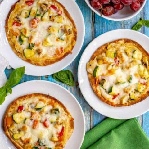 Hummus pita pizzas with veggies take just a few minutes to make and are great served warm or cold. Customize with your favorite hummus flavor and veggie toppings and enjoy for lunch, a snack or a light dinner! #hummus #pizza #healthyrecipes