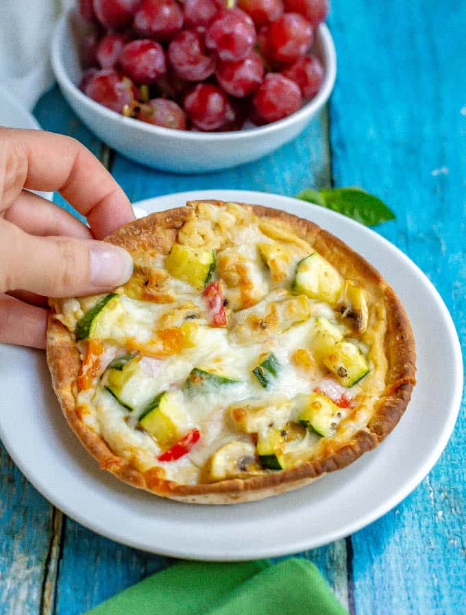 Hummus pita pizza with veggies takes just a few minutes to make and is great served warm or cold. Customize with your favorite hummus flavor and veggie toppings and enjoy for lunch, a snack or a light dinner! #hummus #pizza #healthyrecipes
