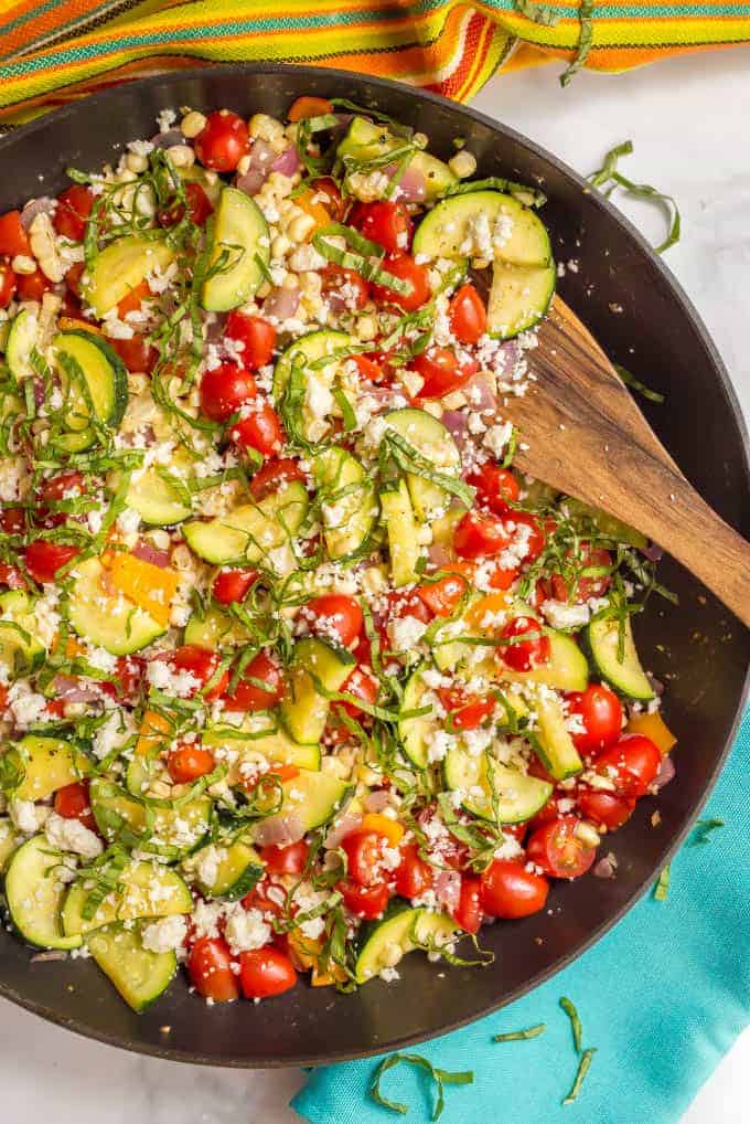 Summer veggie skillet is a colorful, delicious and healthful one-pan side dish with zucchini, peppers, tomatoes, and corn, finished with fresh herbs and cheese! #summer #veggies #vegetarian