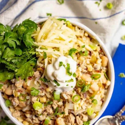 This easy, healthy white turkey chili comes together in about 30 minutes with some simple pantry ingredients. It's full of hearty ground turkey pieces, white beans, rice, corn and green chilies for a hearty meal! #turkeychili #chili #easyrecipe #groundturkey