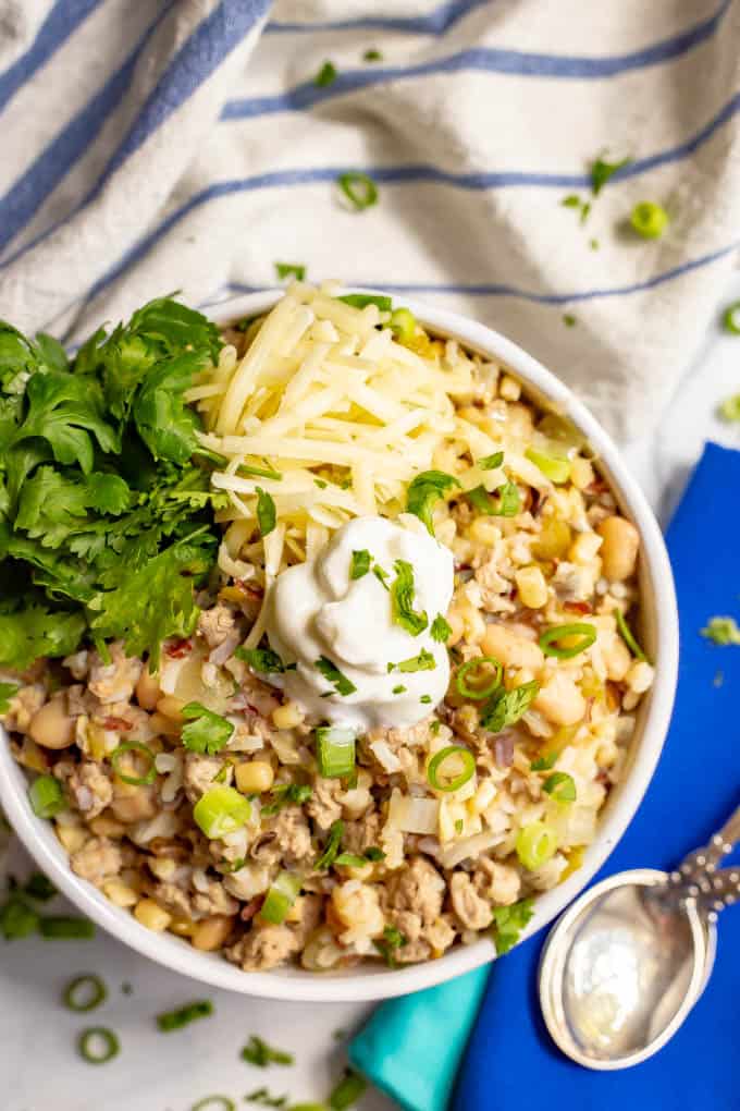 This easy, healthy white turkey chili comes together in about 30 minutes with some simple pantry ingredients. It's full of hearty ground turkey pieces, white beans, rice, corn and green chilies for a hearty meal! #turkeychili #chili #easyrecipe #groundturkey