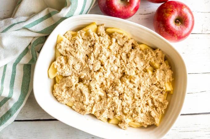 Healthy apple cobbler before baking in a white casserole dish