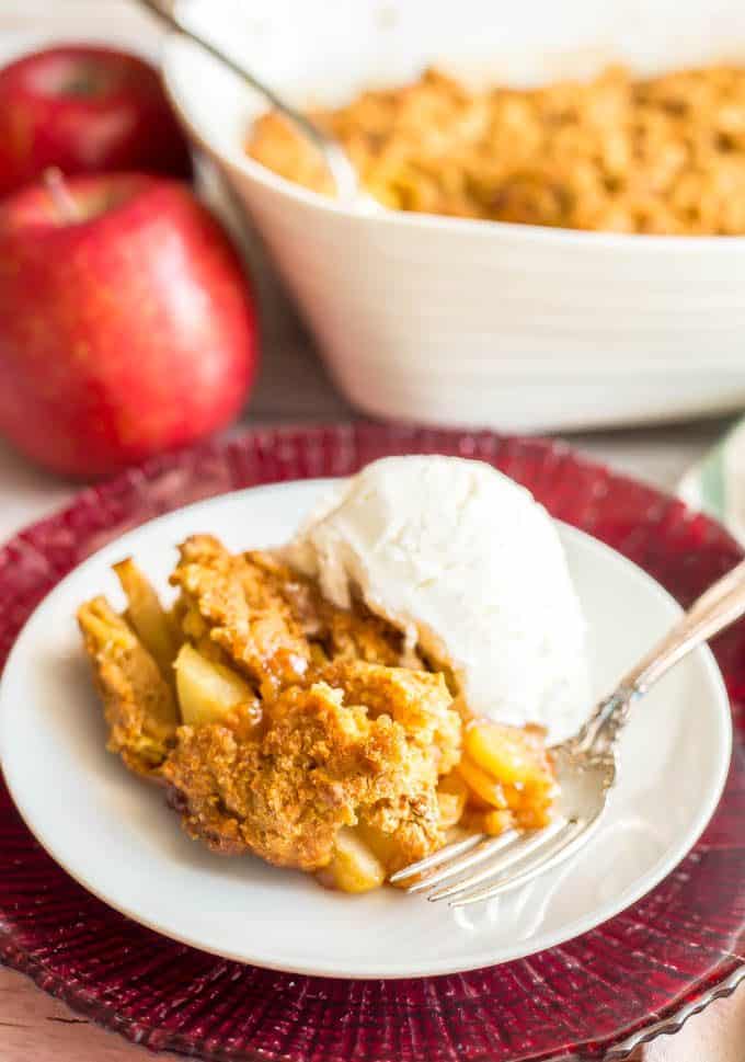 A serving of healthy apple cobbler on a small white plate with a scoop of ice cream on the side
