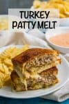 A cheesy turkey patty melt sandwich cut and stacked on a white plate alongside some potato chips with a fry sauce in a bowl in the background.