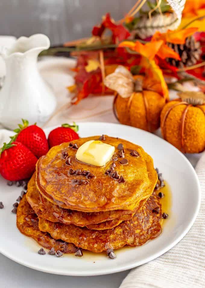 Whole wheat pumpkin pancakes are light, fluffy and full of warm spices and pumpkin flavor. They are naturally sweetened (and can be made vegan) and are perfect for a delicious fall breakfast! #pumpkin #pancakes #breakfast #vegan