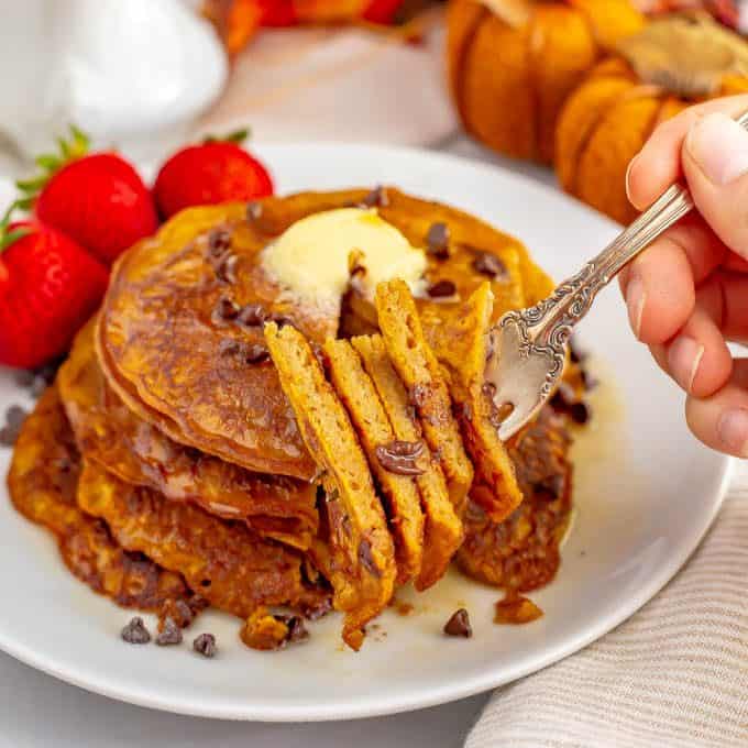 A forkful of a stack of whole wheat pumpkin pancakes about to be eaten