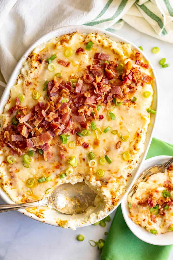 Mashed cauliflower casserole is loaded with cream cheese and cheddar cheese and served with bacon and green onions. This easy recipe is perfect for a low-carb holiday side dish! #cauliflower #lowcarb #glutenfree #holidays #sidedish #Thanksgiving #Christmas