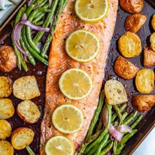 One-pan salmon and potatoes with green beans is an easy sheet pan dinner with wild-caught salmon, baby red potatoes and green beans, all roasted and topped with feta cheese and a lemony vinaigrette. #salmon #potatoes #sheetpan #easydinner #seafood