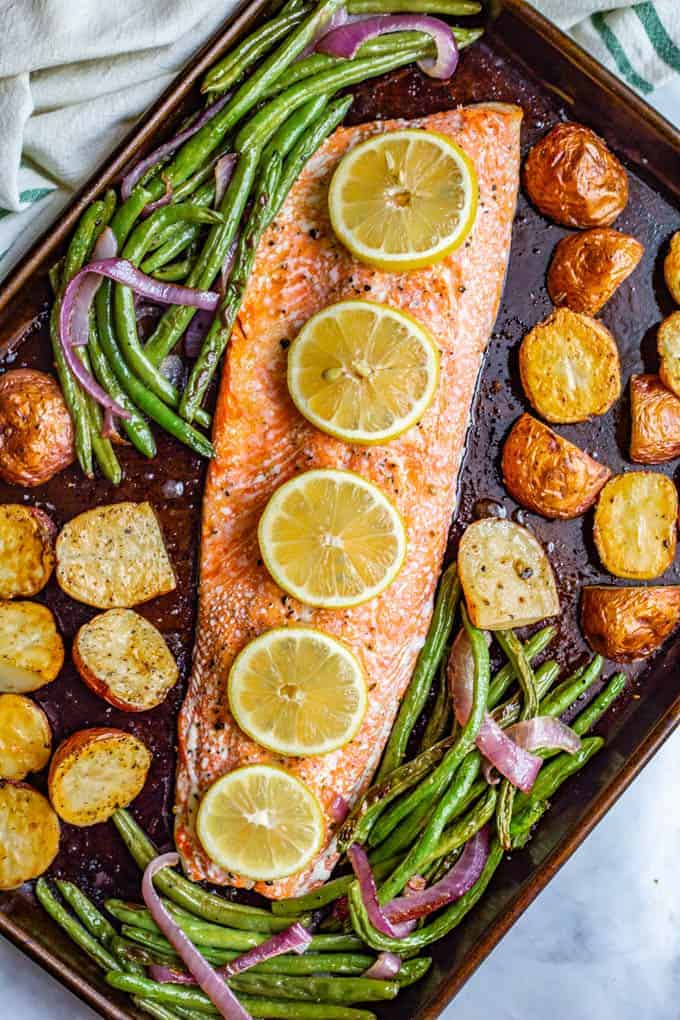 One-pan salmon and potatoes with green beans is an easy sheet pan dinner with wild-caught salmon, baby red potatoes and green beans, all roasted and topped with feta cheese and a lemony vinaigrette. #salmon #potatoes #sheetpan #easydinner #seafood