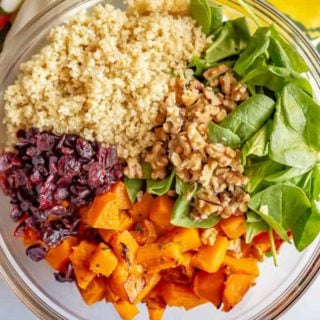 This warm butternut squash salad with quinoa is mixed with spinach, dried cranberries, walnuts and Parmesan and tossed with an apple cider vinaigrette to give it extra flavor! It’s great as a side dish or vegetarian main dish. #butternutsquash #quinoa #wintersalad #vegetarian #glutenfree