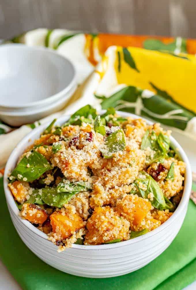 This warm butternut squash salad with quinoa is mixed with spinach, dried cranberries, walnuts and Parmesan and tossed with an apple cider vinaigrette to give it extra flavor! It’s great as a side dish or vegetarian main dish. #butternutsquash #quinoa #wintersalad #vegetarian #glutenfree