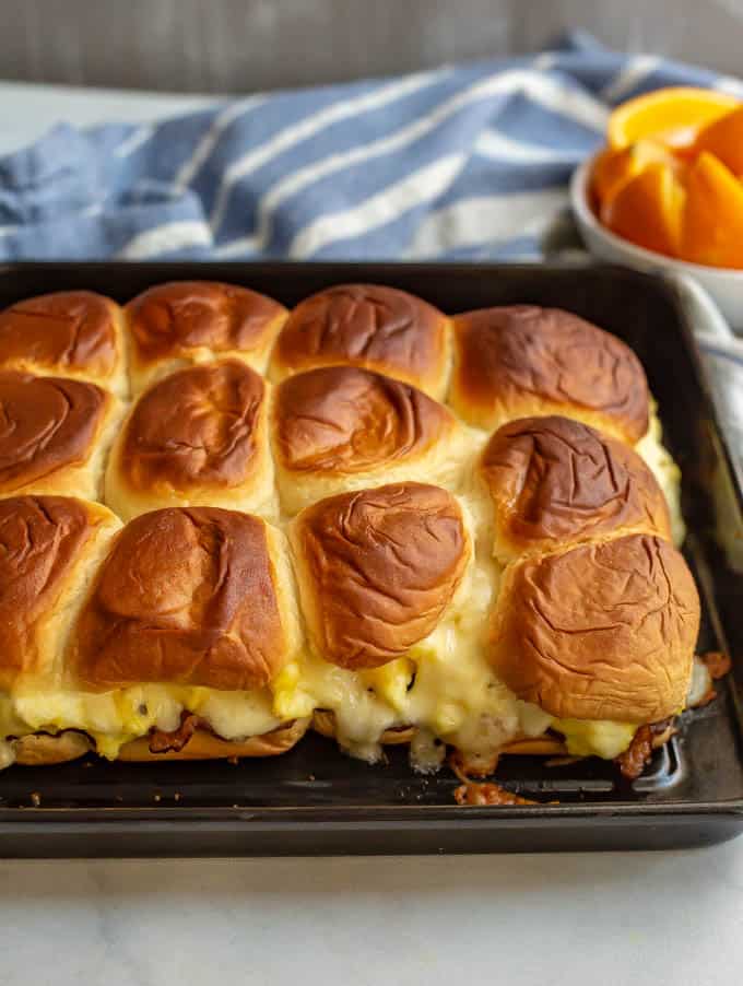 Cheesy baked breakfast sliders with eggs, bacon and cheese on a baking sheet after being cooked