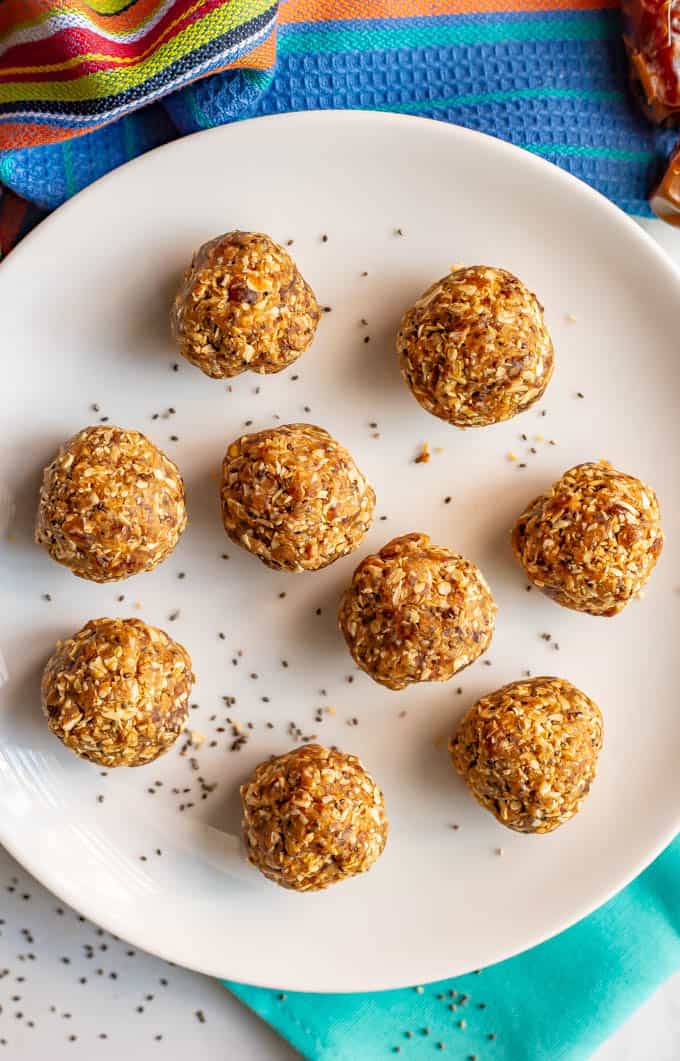 Healthy peanut butter energy balls on a white plate with a sprinkling of chia seeds and napkins underneath