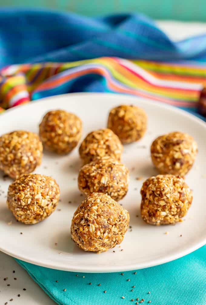 Healthy peanut butter energy balls arranged on a white plate with a turquoise napkin underneath