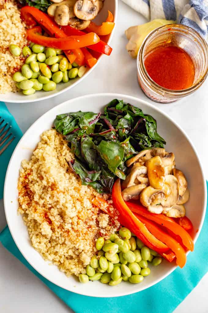 Warm Asian quinoa power bowls are full of wholesome, colorful and delicious veggies and finished off with an easy, but addictive, soy ginger dressing. Vegan, gluten-free and dairy-free. #veganrecipes #meatlessMonday #vegetariandinner #quinoa #quinoabowl
