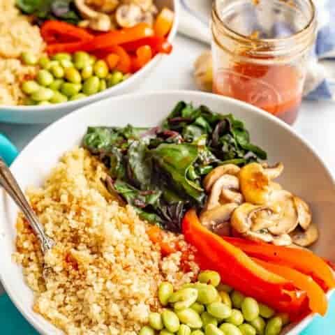 Warm Asian quinoa power bowls are full of wholesome, colorful and delicious veggies and finished off with an easy, but addictive, soy ginger dressing. Vegan, gluten-free and dairy-free. #veganrecipes #meatlessMonday #vegetariandinner #quinoa #quinoabowl
