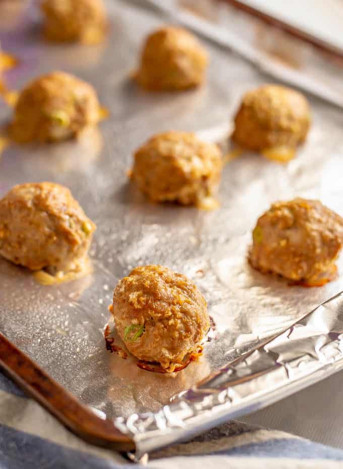 Baked Asian style meatballs on a baking sheet lined with aluminum foil