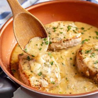 Easy skillet pork chops with gravy are tender, creamy and seriously comforting! This easy one-pan recipe requires just a few simple ingredients and is ready in only 25 minutes! #porkchops #easydinner #30minutemeals #porkdinner #porkrecipes
