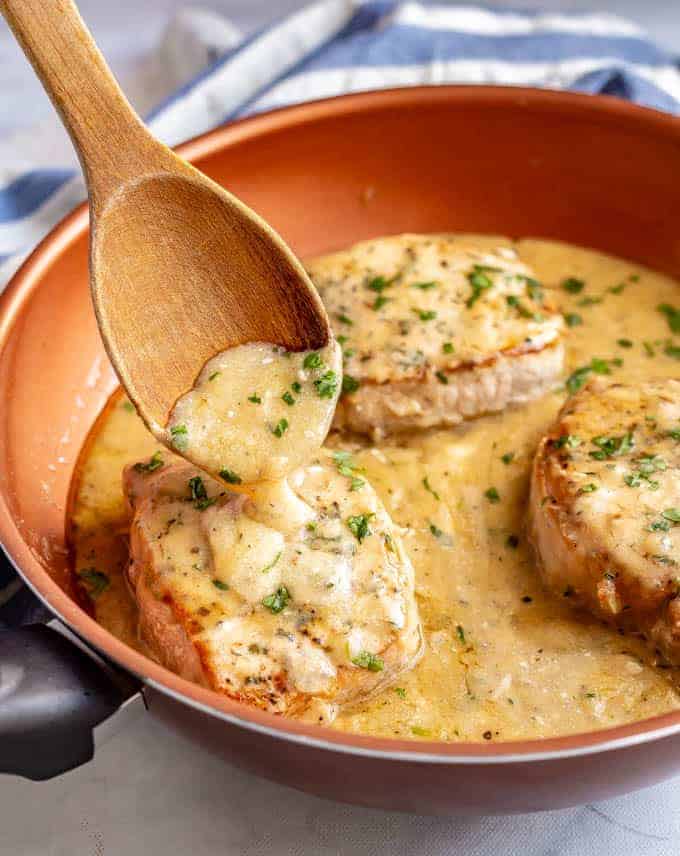 Easy skillet pork chops with gravy are tender, creamy and seriously comforting! This easy one-pan recipe requires just a few simple ingredients and is ready in only 25 minutes! #porkchops #easydinner #30minutemeals #porkdinner #porkrecipes