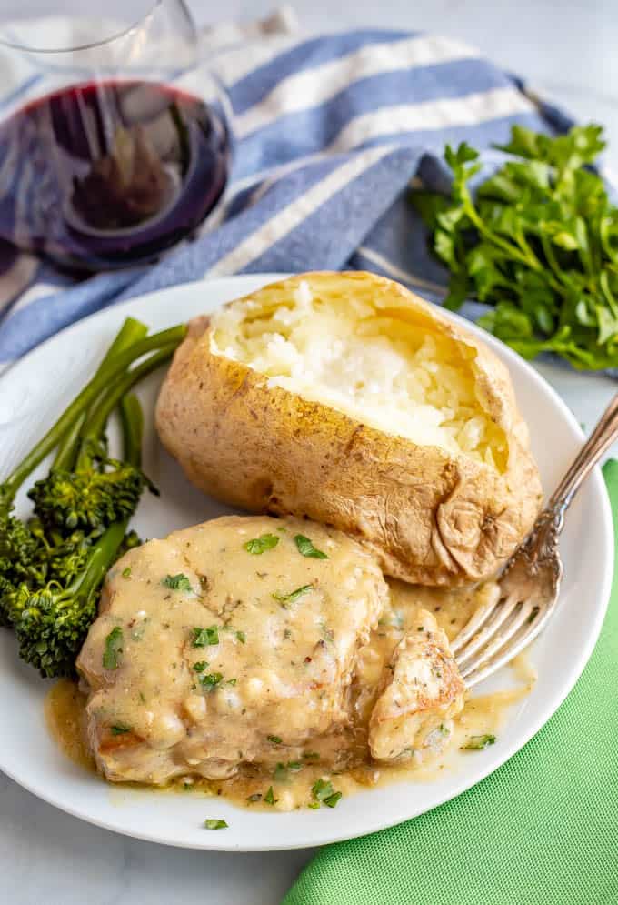 Easy skillet pork chops with gravy are tender, creamy and seriously comforting! This easy one-pan recipe requires just a few simple ingredients and is ready in only 25 minutes! #porkchops #easydinner #30minutemeals #porkdinner #porkrecipes
