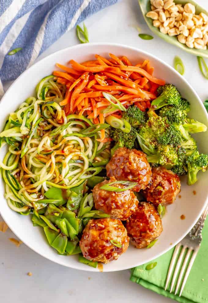 Asian turkey meatballs with zucchini noodles and veggies in a large white bowl