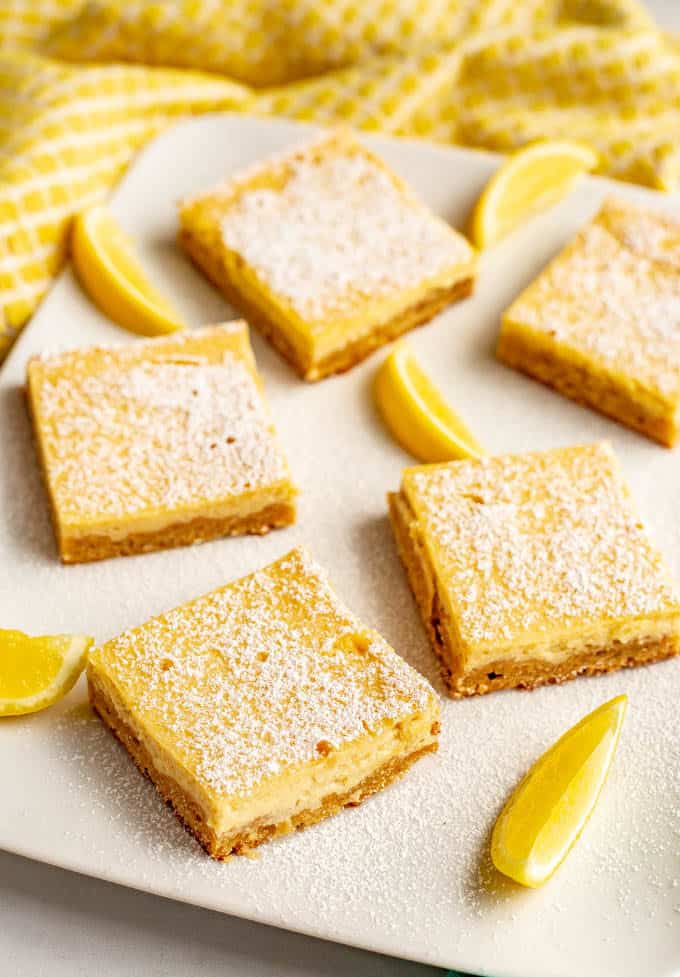 Healthy lemon bars have a shortbread crust and a silky smooth slightly sweet, slightly tart creamy lemon filling on top. These bars are whole wheat and naturally sweetened - and just 7 ingredients! #lemonbars #lemonsquares #lemon #dessert