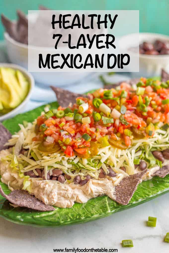 This quick + easy healthy 7-layer Mexican dip is creamy and cheesy, with some crisp, fresh flavors to balance it out. Full of taco flavor and your favorite toppings, this gorgeous dip is perfect for parties! #7layerdip #appetizers #partyfood #cincodemayo #mexicandip