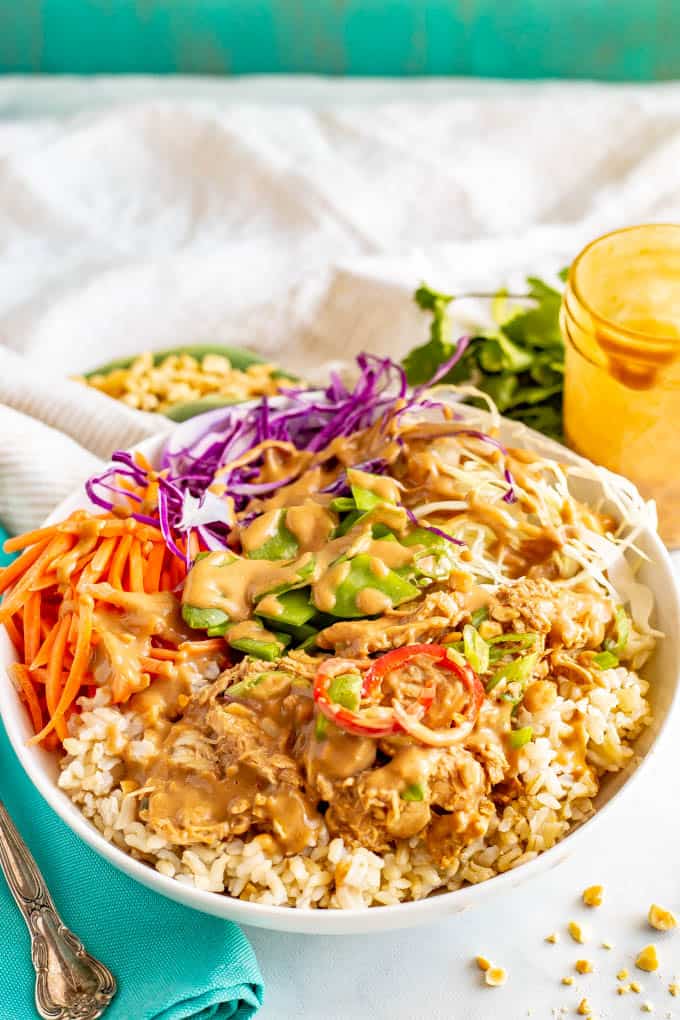 Peanut chicken rice and cabbage bowls are a crunchy, colorful and delicious way to serve peanut chicken. They’re drizzled with an easy but irresistible peanut dressing. #peanutchicken #ricebowls #veggiebowls #mealprep