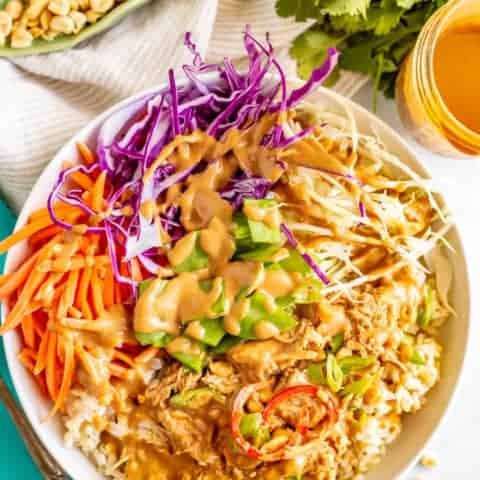 Peanut chicken rice and cabbage bowls are a crunchy, colorful and delicious way to serve peanut chicken. They’re drizzled with an easy but irresistible peanut dressing. #peanutchicken #ricebowls #veggiebowls #mealprep