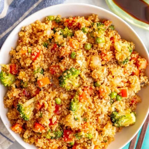 This vegetarian quinoa fried rice is quick and easy to make and loaded with fluffy quinoa and tender veggies. This 20-minute recipe is perfect for a meatless weeknight dinner! #friedrice #quinoa #vegetarianrecipes #easyvegetariandinners