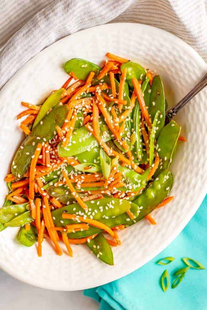 Sesame snow peas and carrots is a quick and easy side dish that’s ready in just 10 minutes! You’ll love how colorful and tasty this recipe is for a quick weeknight veggie side! #snowpeas #carrots #sidedish #easysides #glutenfreerecipes