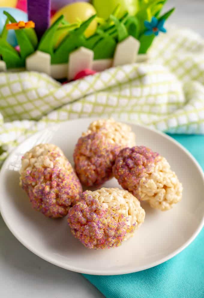 Easter egg Rice Krispie treats dipped in sprinkles and served on a white plate